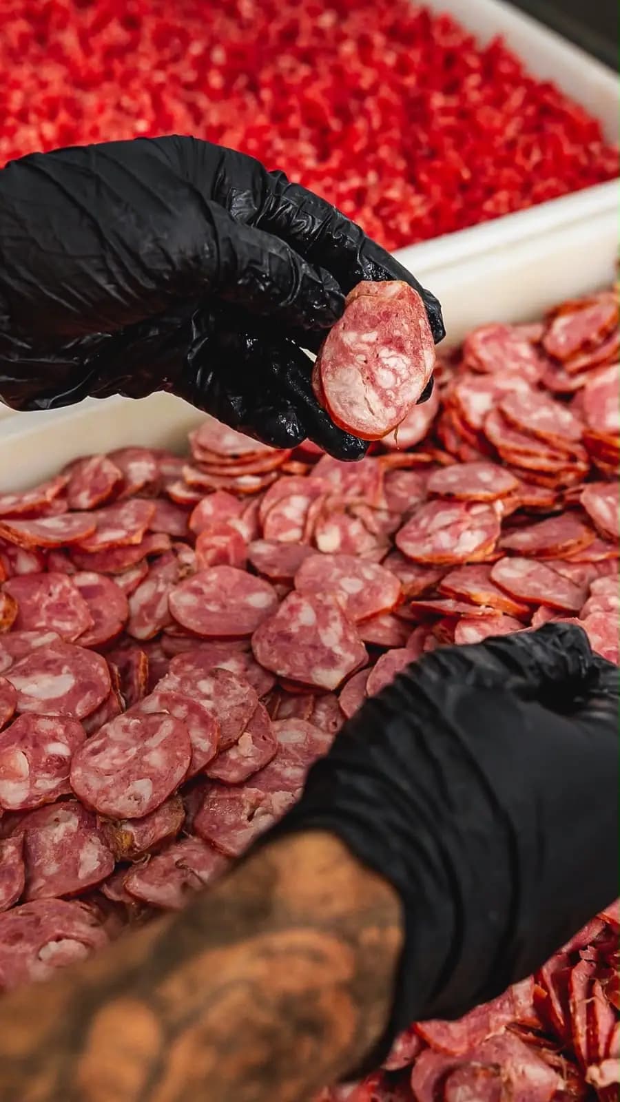 Fatias de calabresa preparadas com luvas e higiene pela equipe da Distribuidora RR