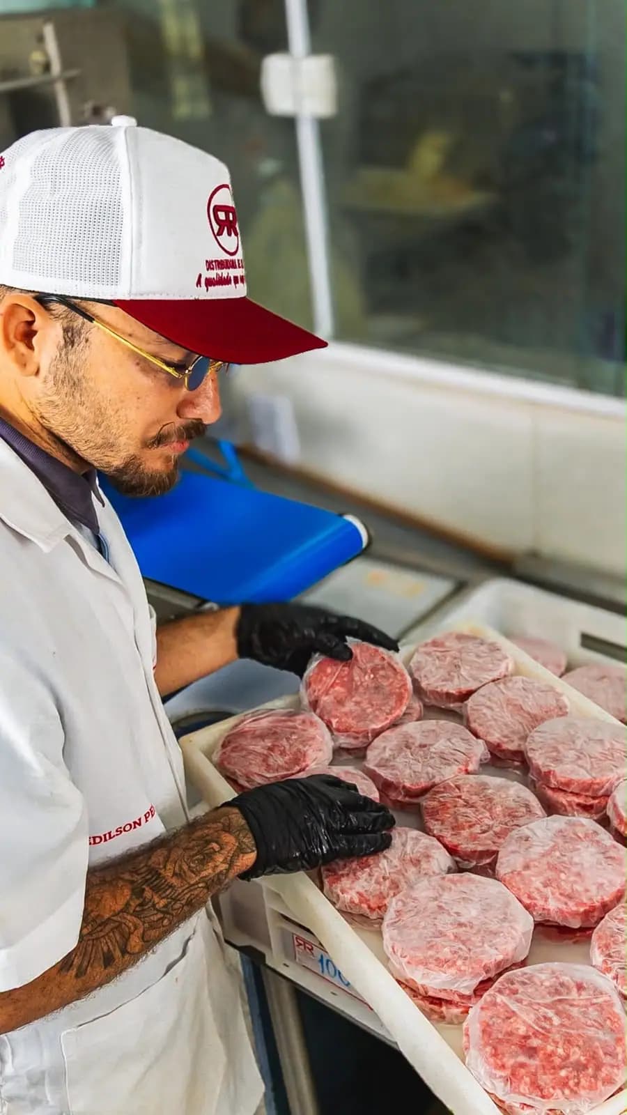 Hambúrgueres porcionados sendo organizados na operação da Distribuidora RR